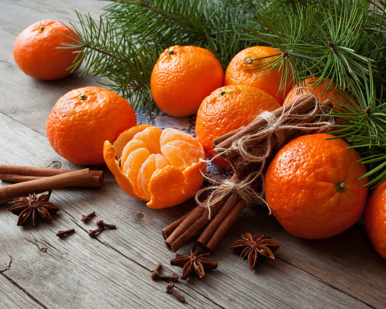 Вкусные спелые мандарины с корицей и бадьяном на столе с еловой веткой