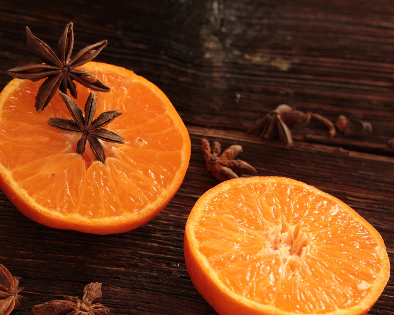 Две половины апельсина на деревянном столе с бадьяном