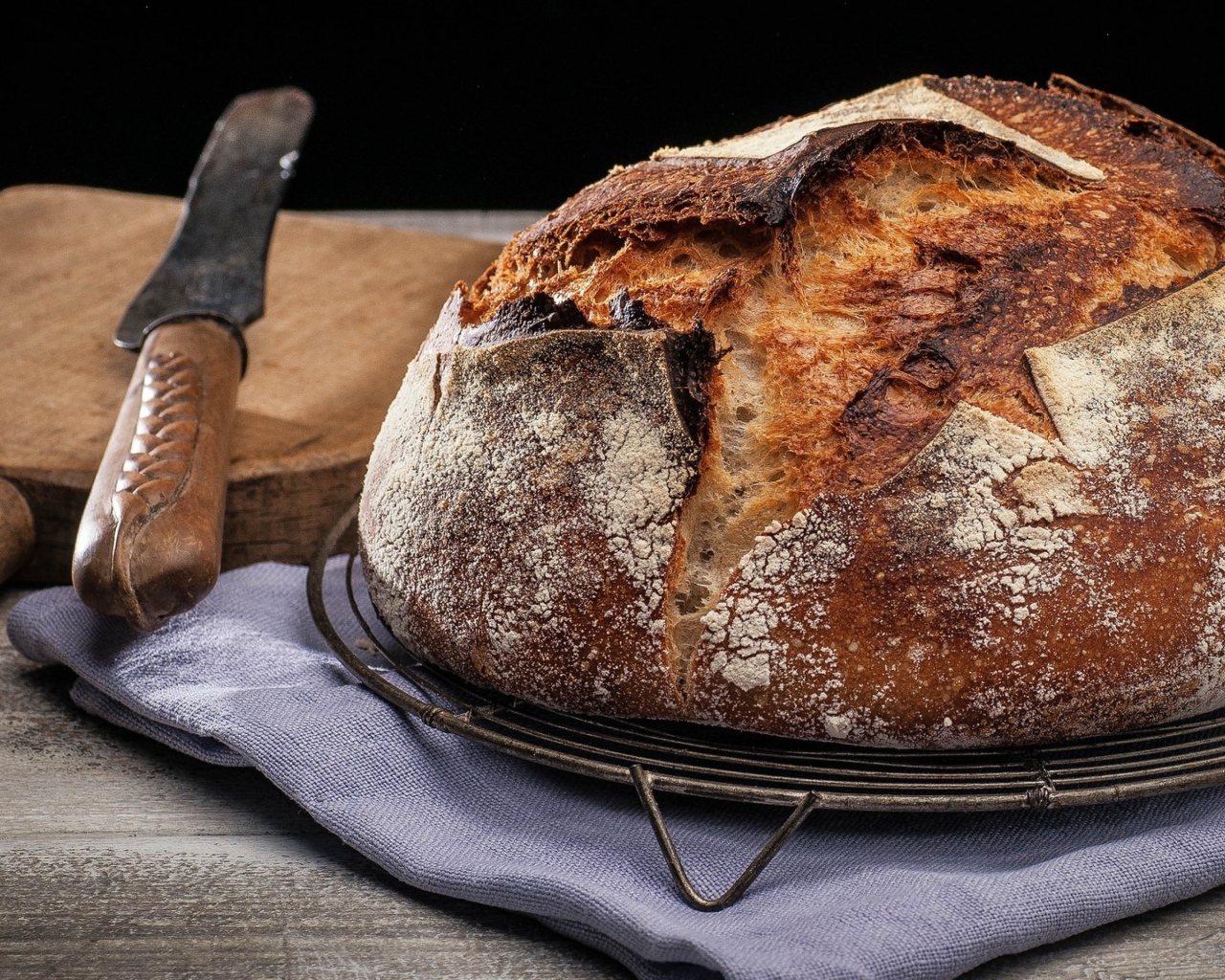 Зажареный круглый хлеб на столе с ножом