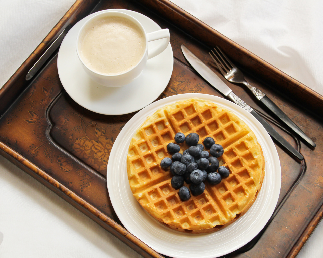 Чашка кофе и сладкие вафли с черникой на завтрак