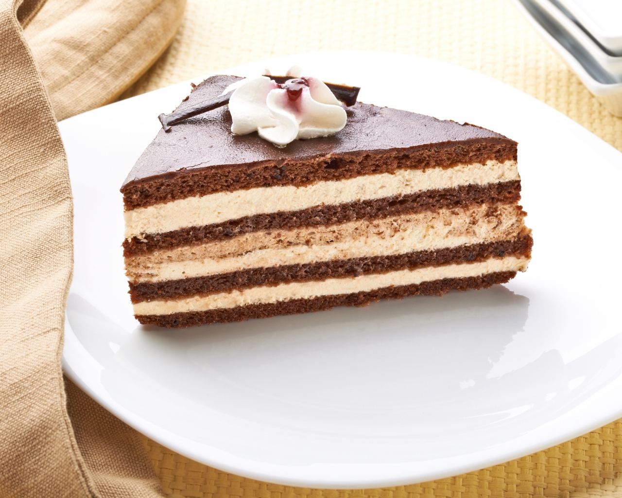 Большой кусок торта с кремом украшен цветком