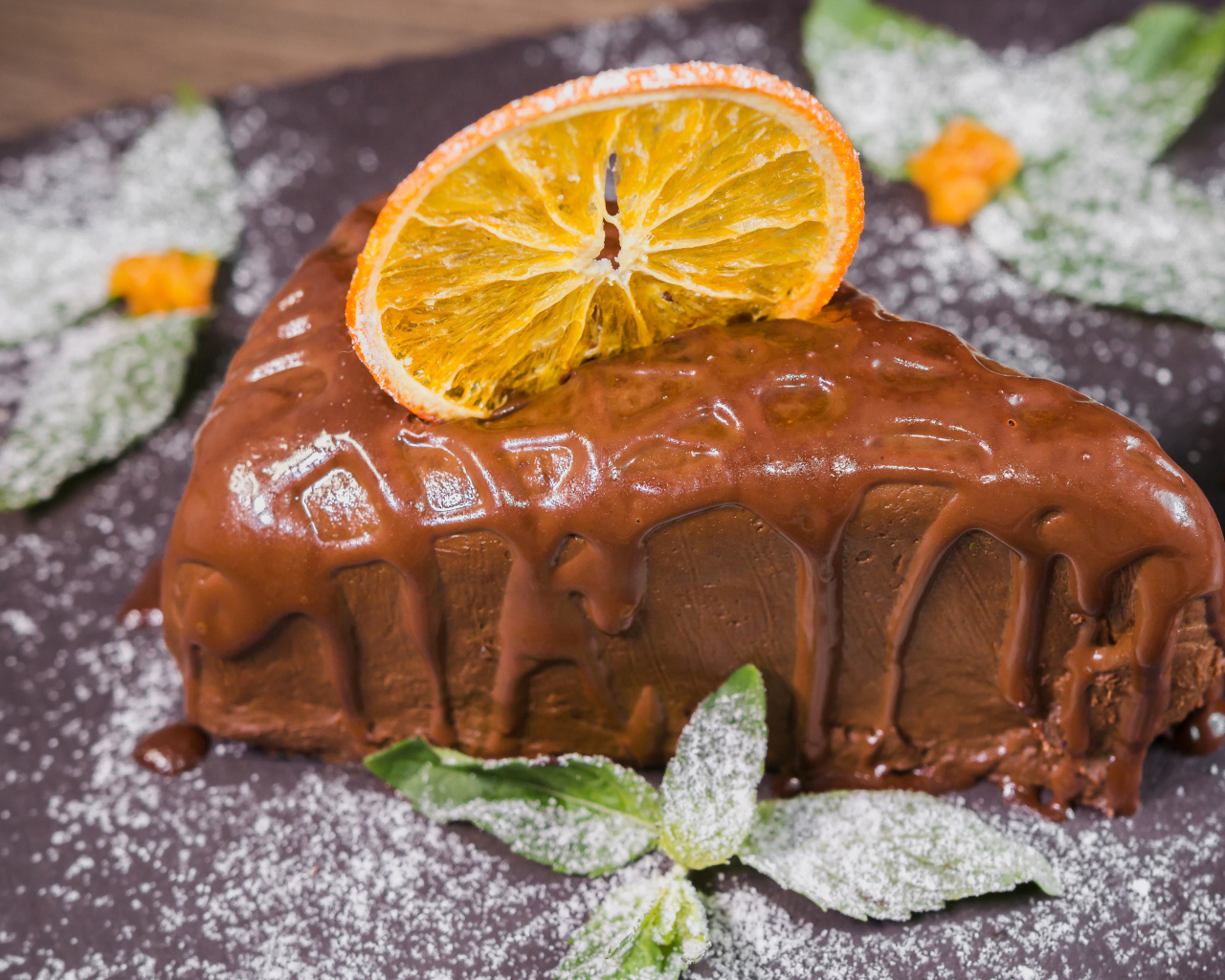 Кусок пирожного с шоколадом и кусочком апельсина