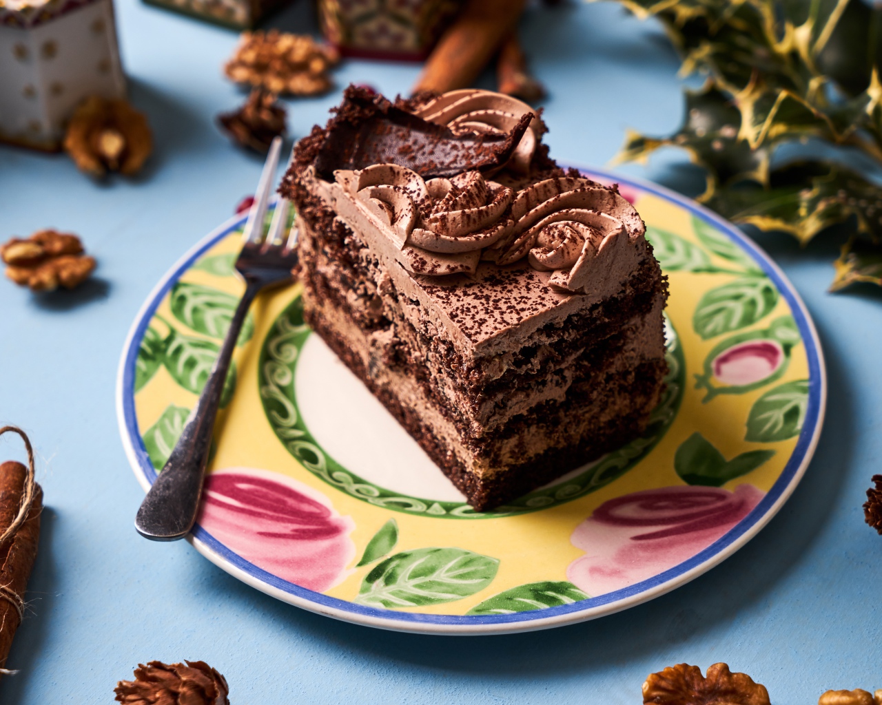 Кусок торта с кремом и шоколадом на тарелке 