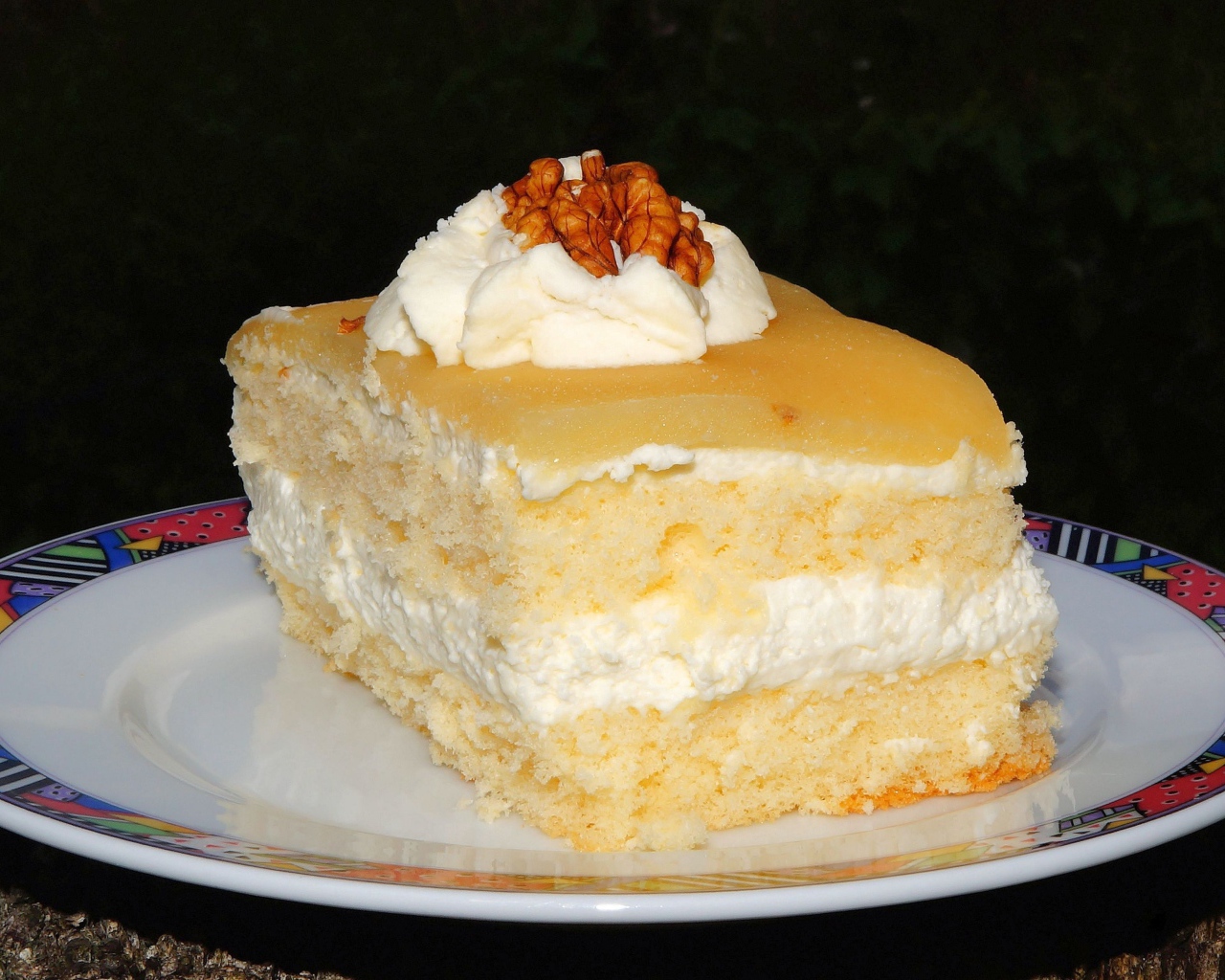 Кусок торта со сливочным кремом и грецкими орехами