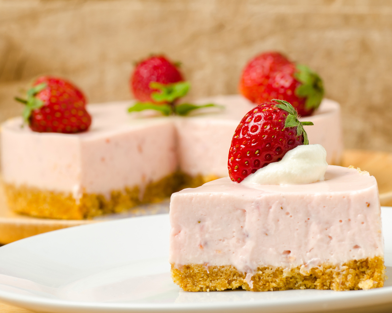 Кусок торта с клубникой на белой тарелке