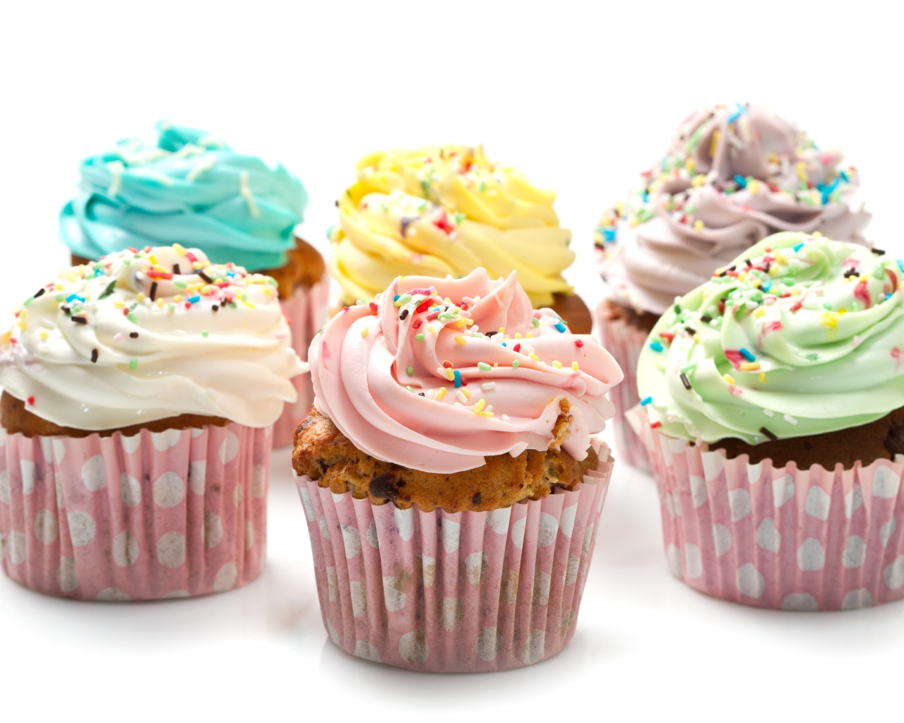 Аппетитные капкейки с кремом на белом фоне