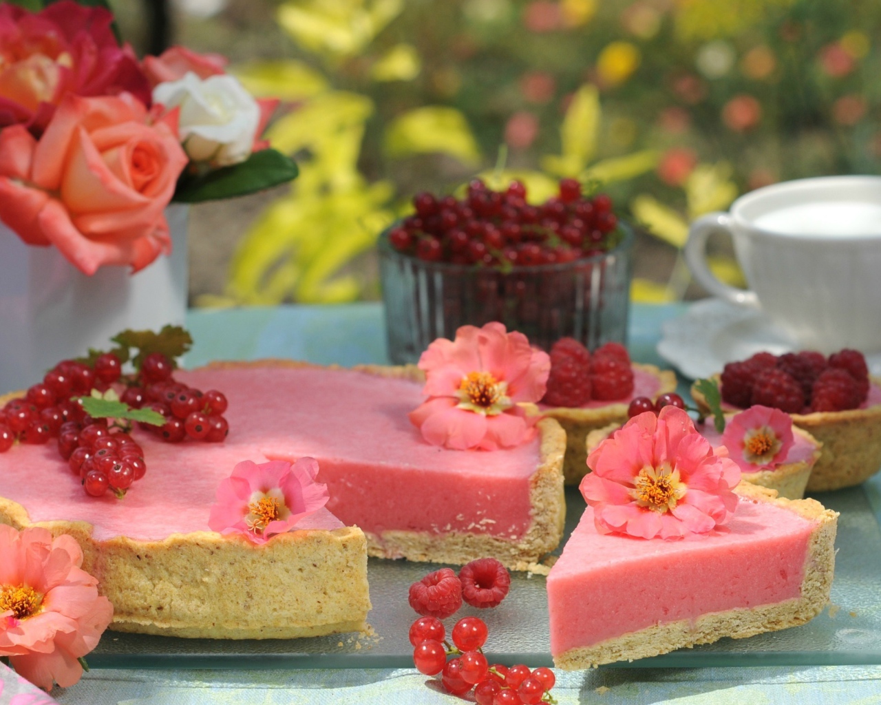 Аппетитный пирог с ягодами малины и красной смородины на столе с цветами