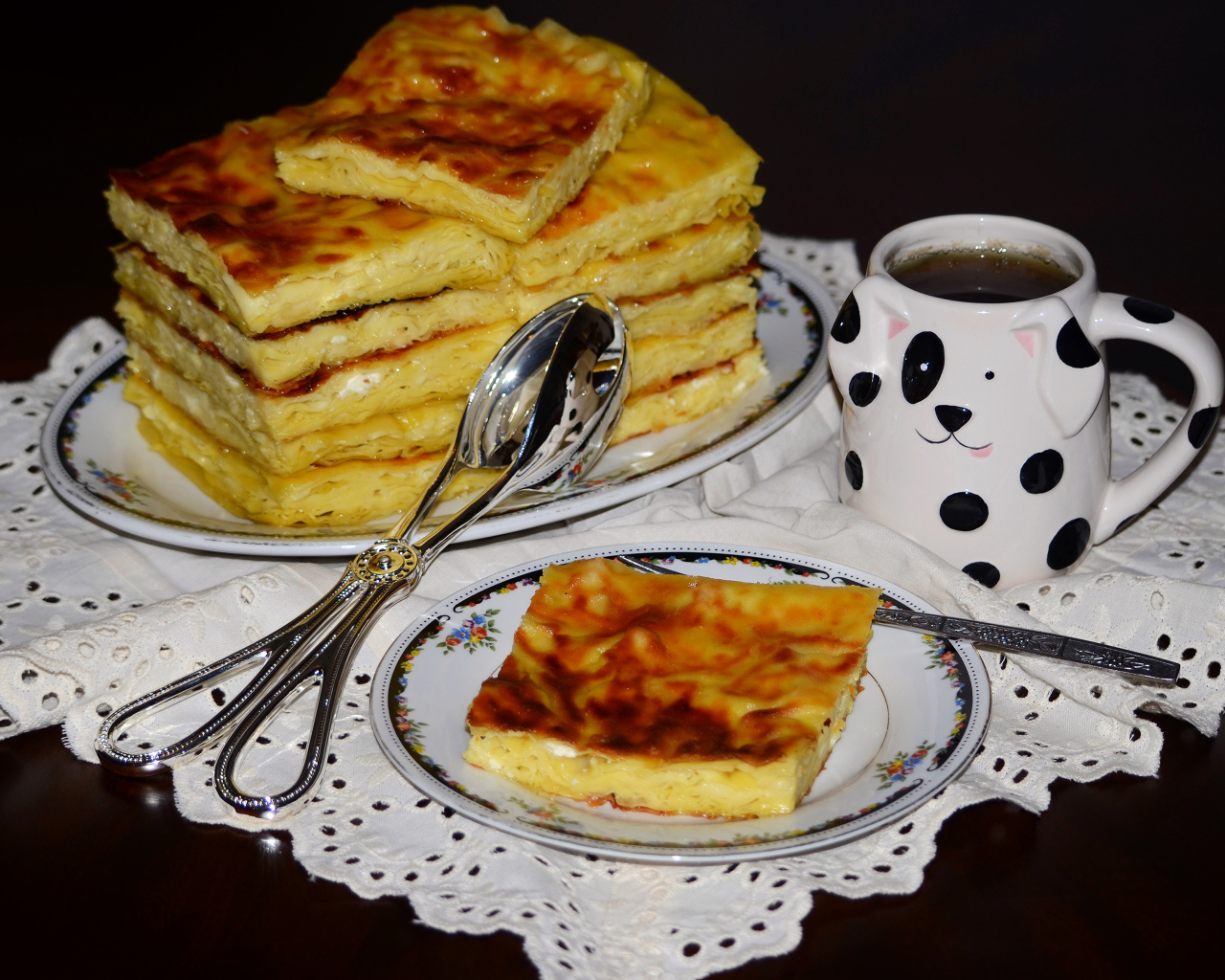 Аппетитный сладкий пирог с чашкой чая на столе