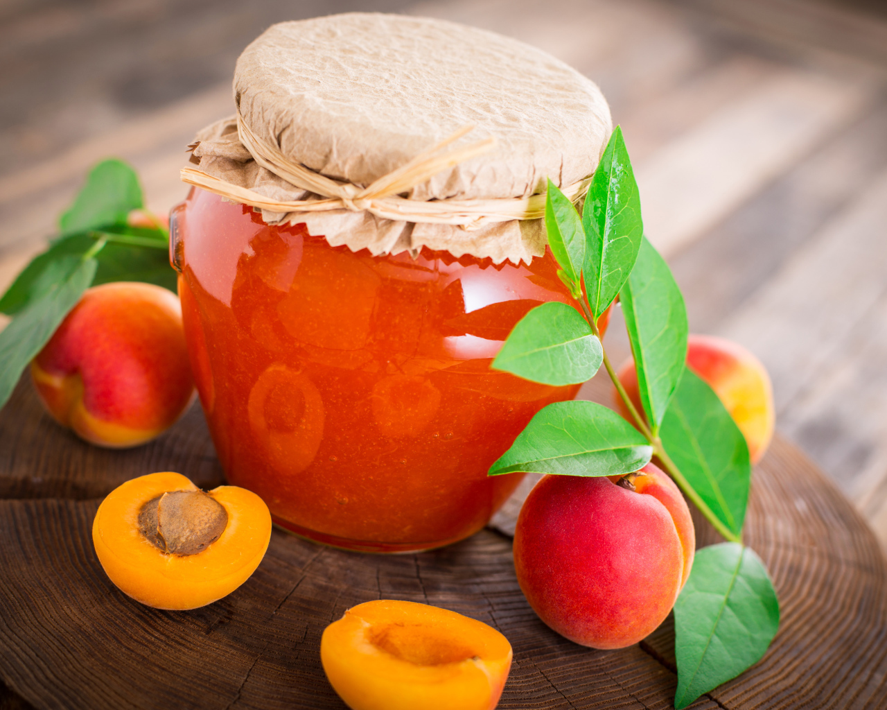 Абрикосовое варенье в банке на столе с абрикосами