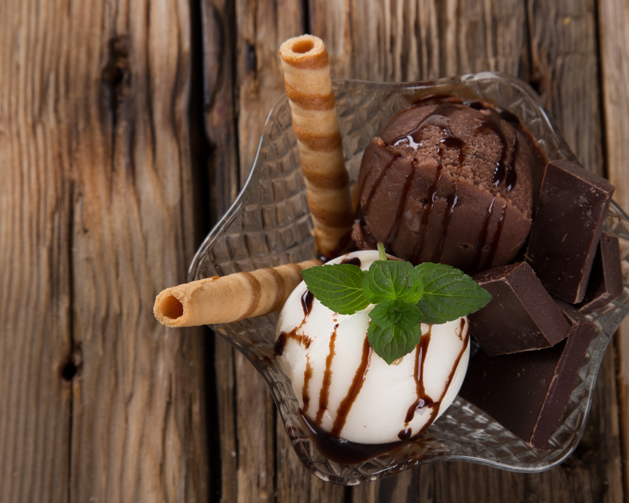 Шарик сливочного и шоколадного мороженого в пиале с трубочками