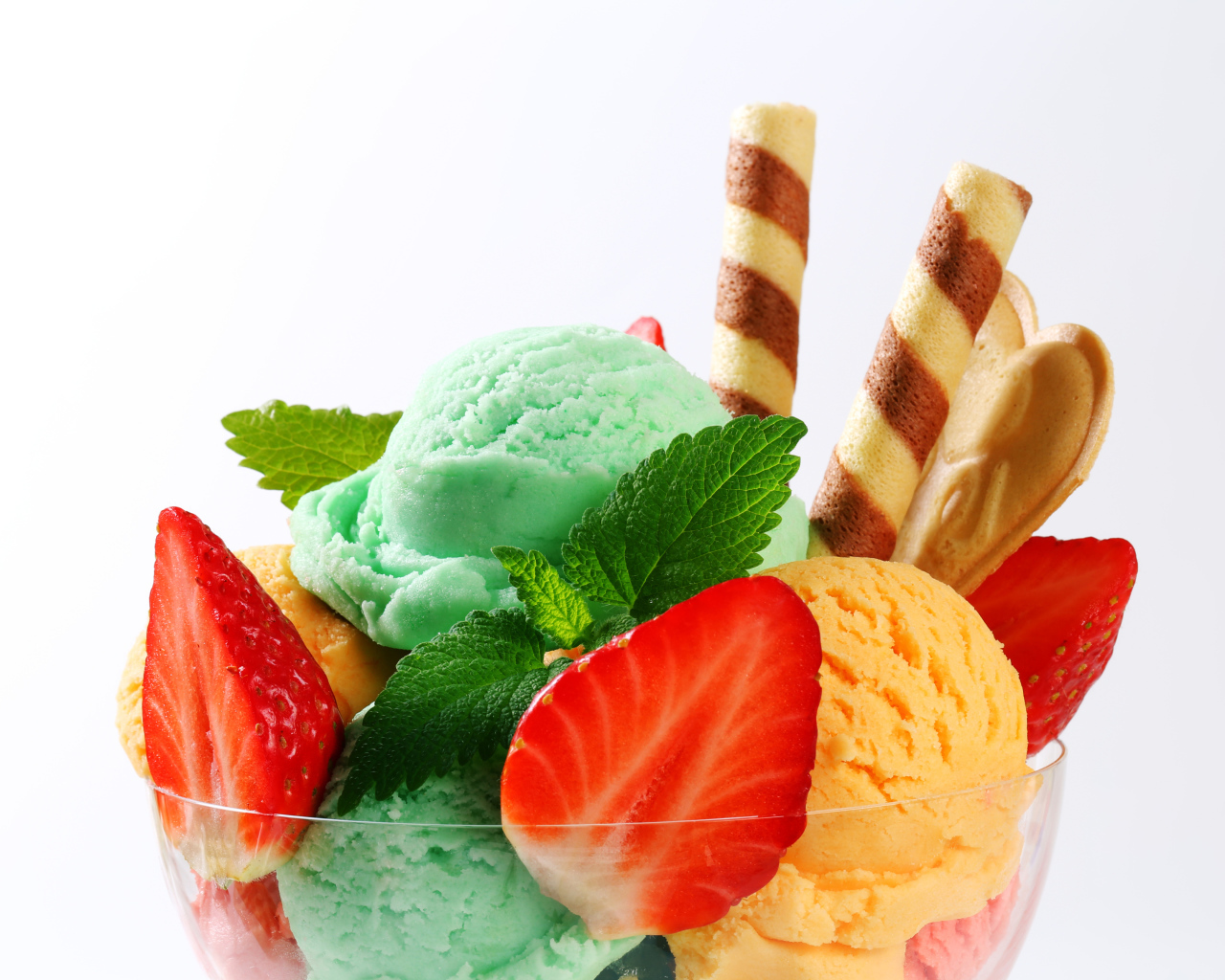 Шарики разноцветного мороженого с клубникой и трубочками