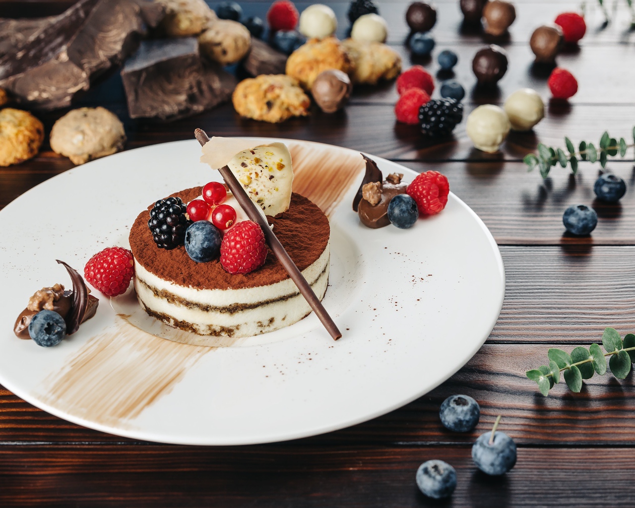 Пирожное с ягодами и шоколадом на белой тарелке 