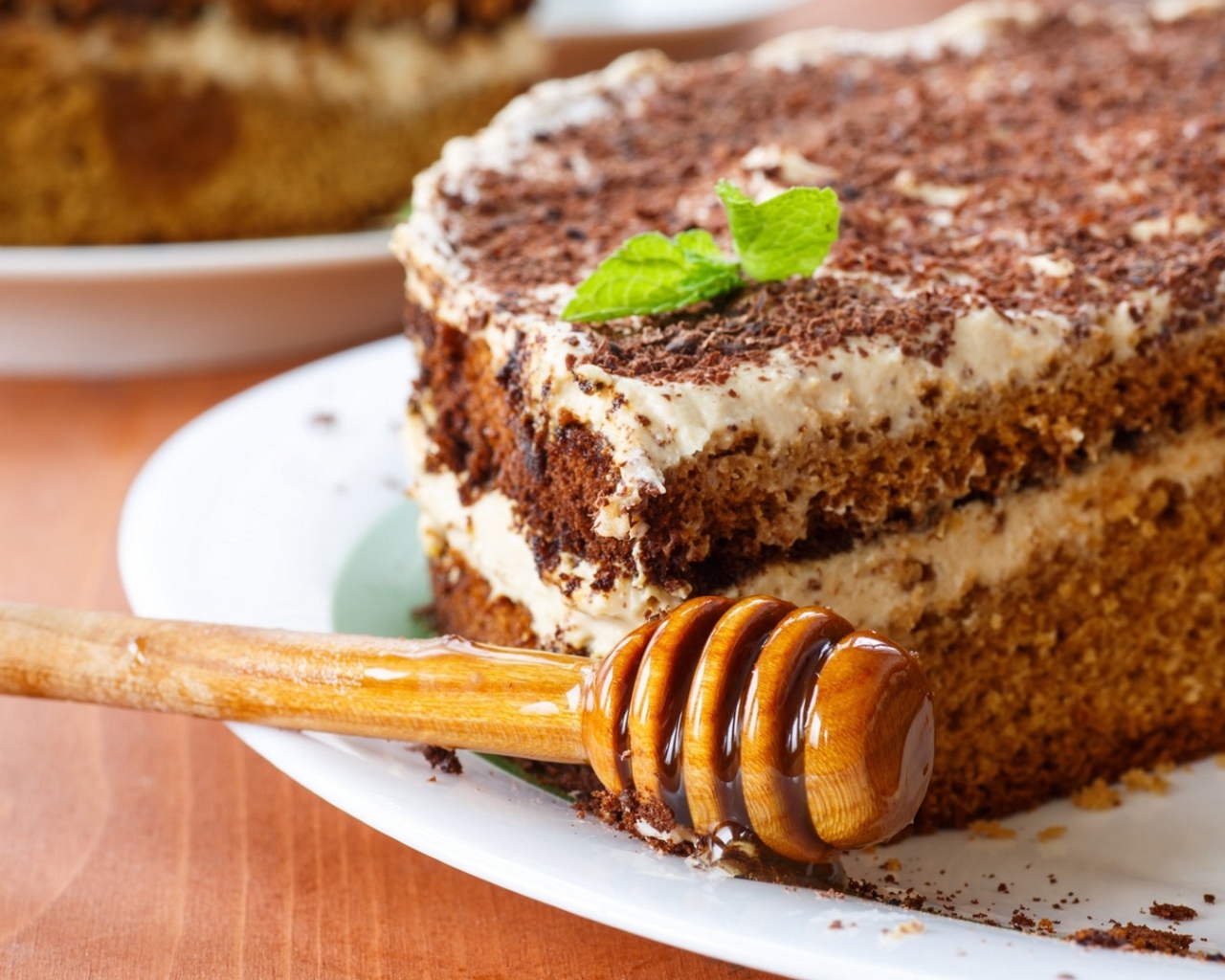 Торт с кремом и шоколадом на тарелке с ложкой для меда