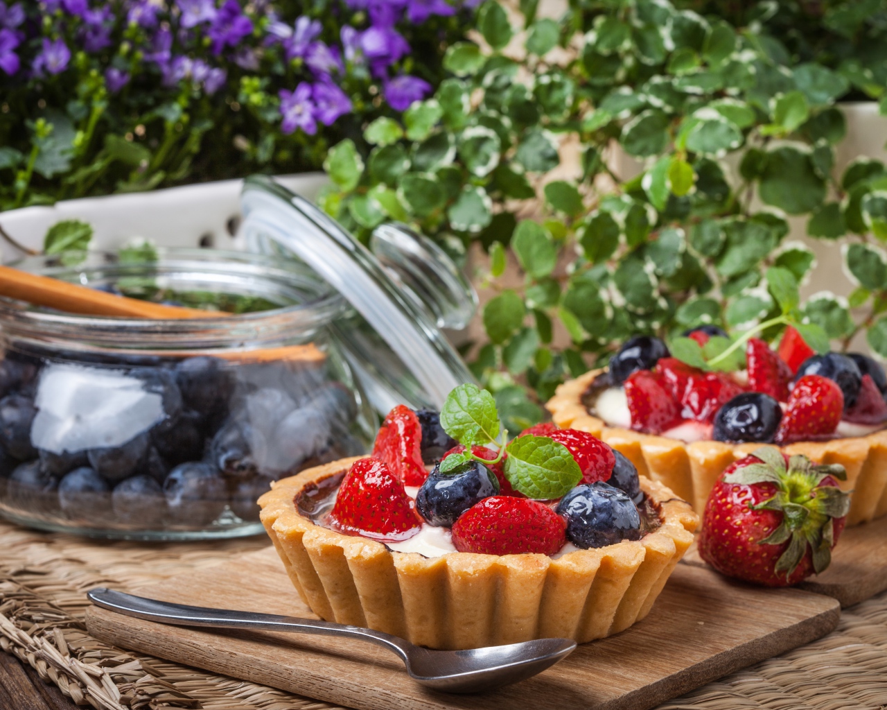 Пирожные с ягодами клубники и черники на столе