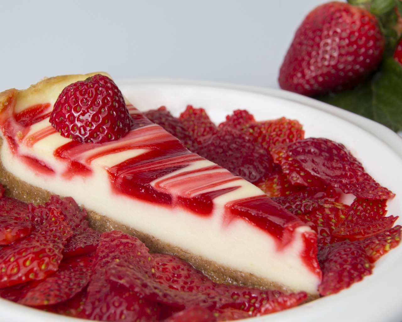 Чизкейк с ягодами клубники в белой тарелке 