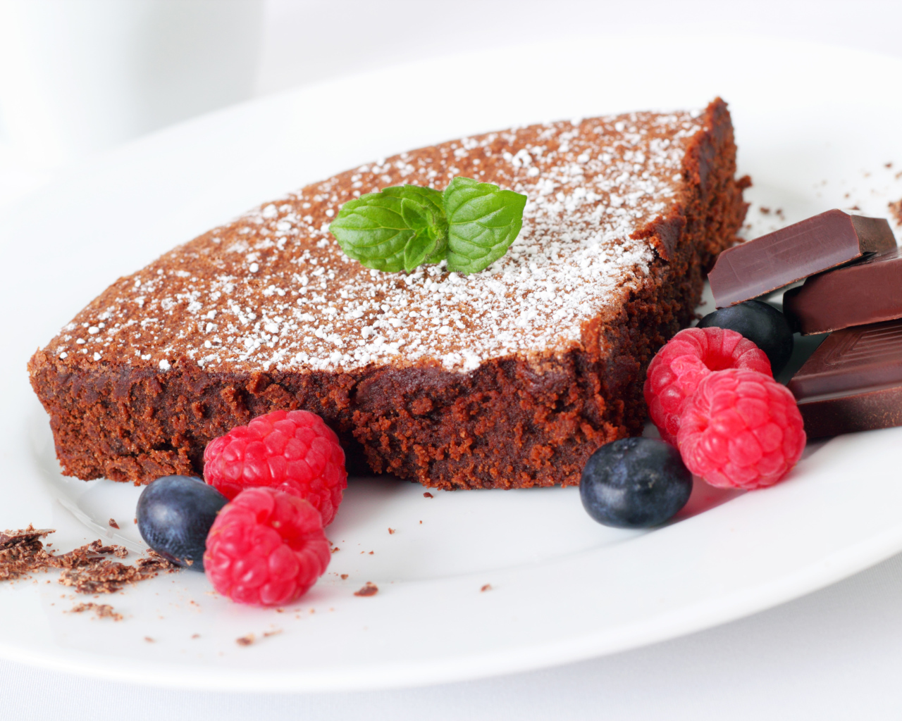 Шоколадный десерт брауни с ягодами малины и черники