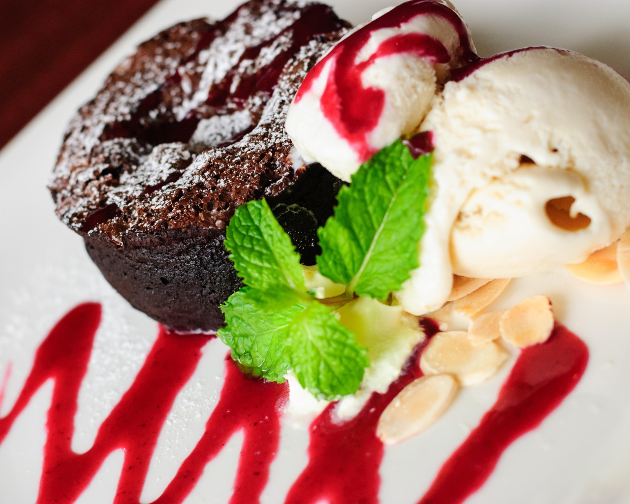 Шоколадное пирожное с мороженым и джемом на тарелке