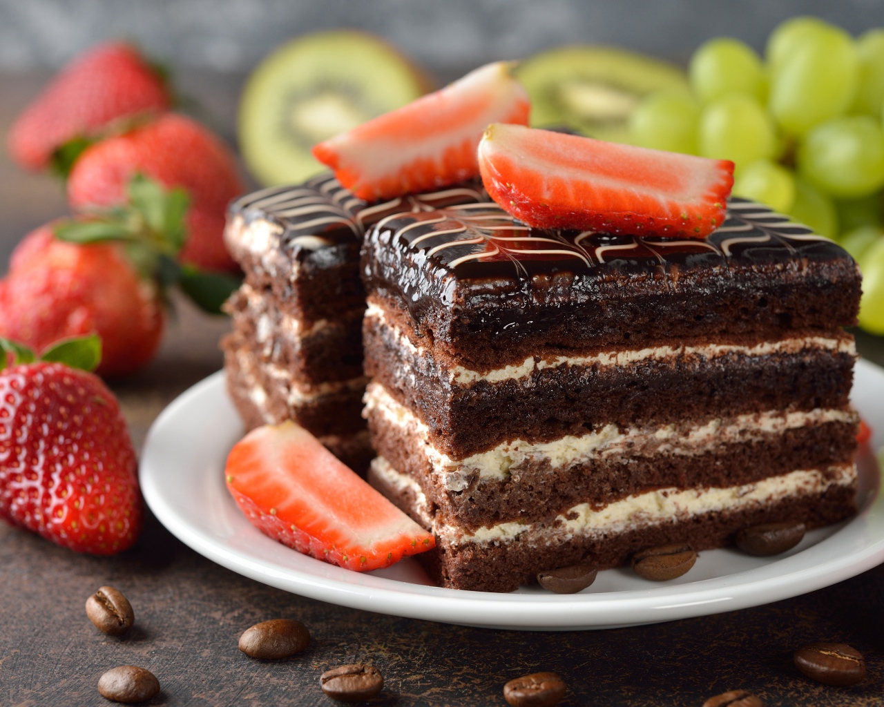 Шоколадное пирожное с клубникой и виноградом на столе