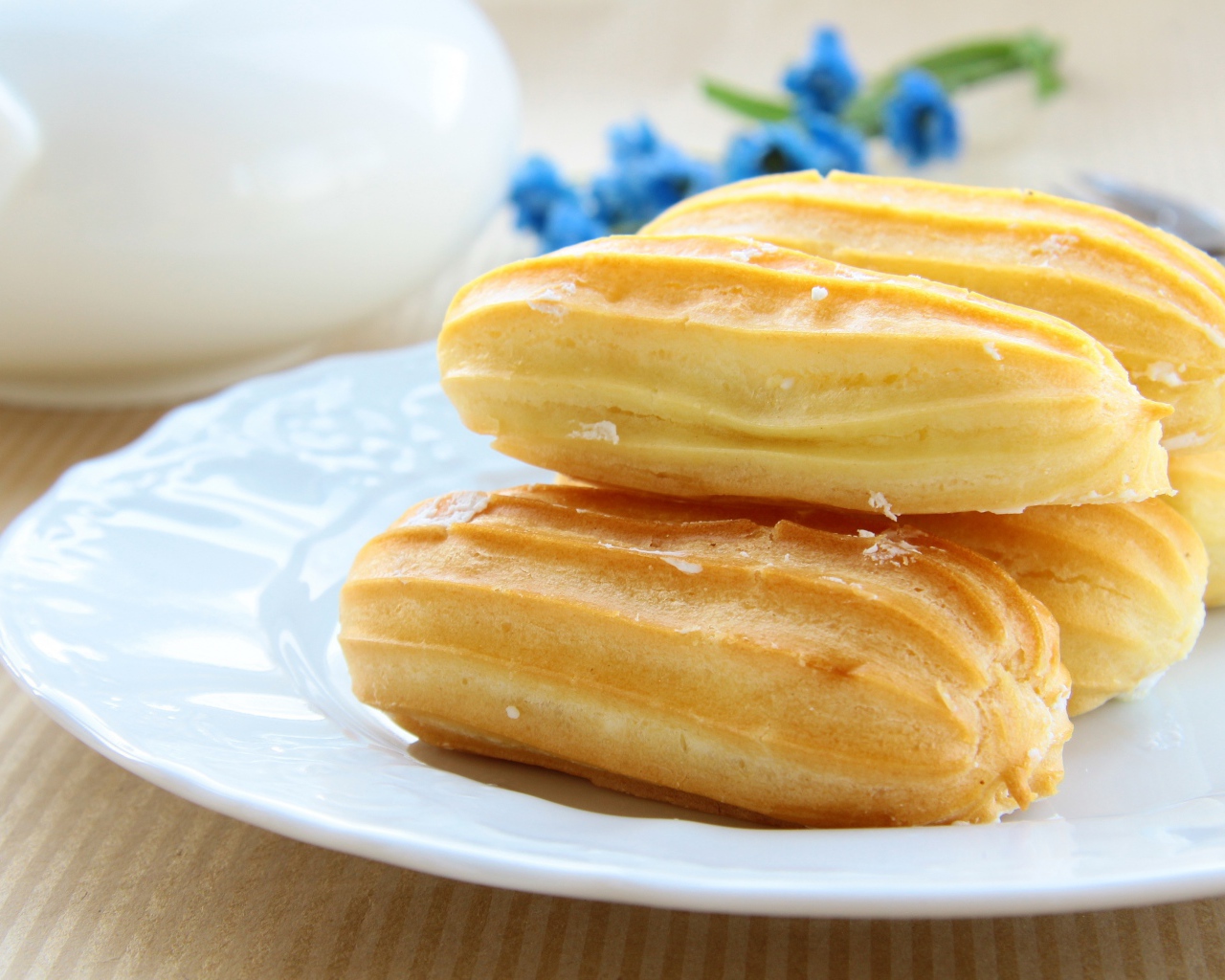 Заварные пирожные на большой белой тарелке 