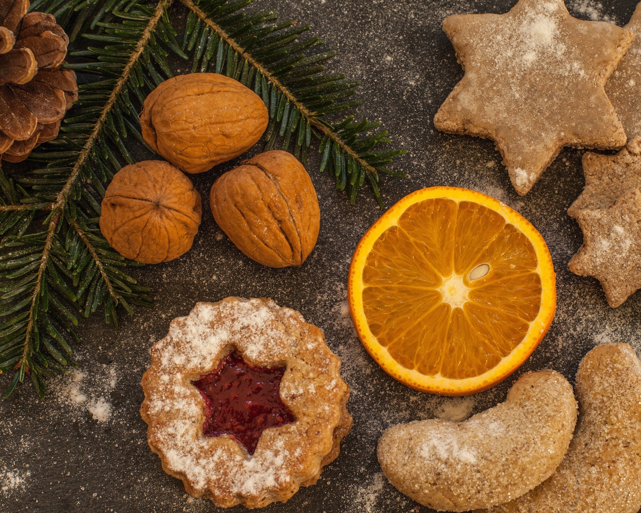 Печенье на столе с грецкими орехами и кусочком апельсина
