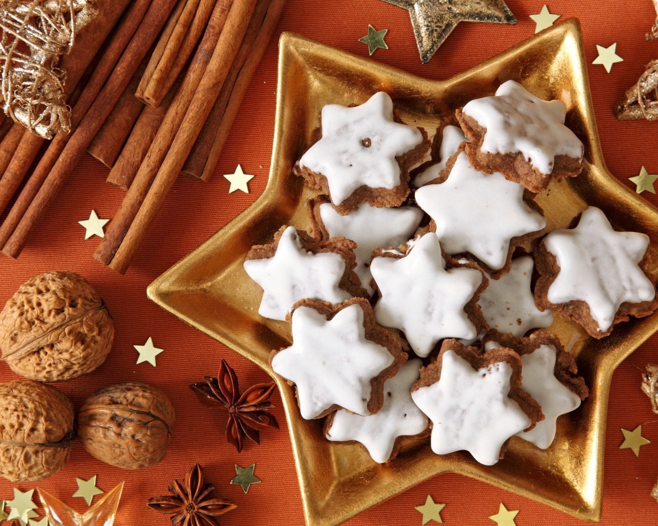 Печенье с глазурью на столе с орехами, корицей и бадьяном