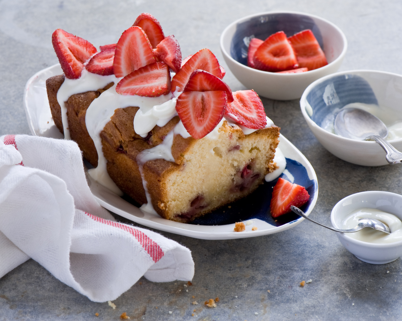 Кекс с кремом на тарелке со свежей клубникой 