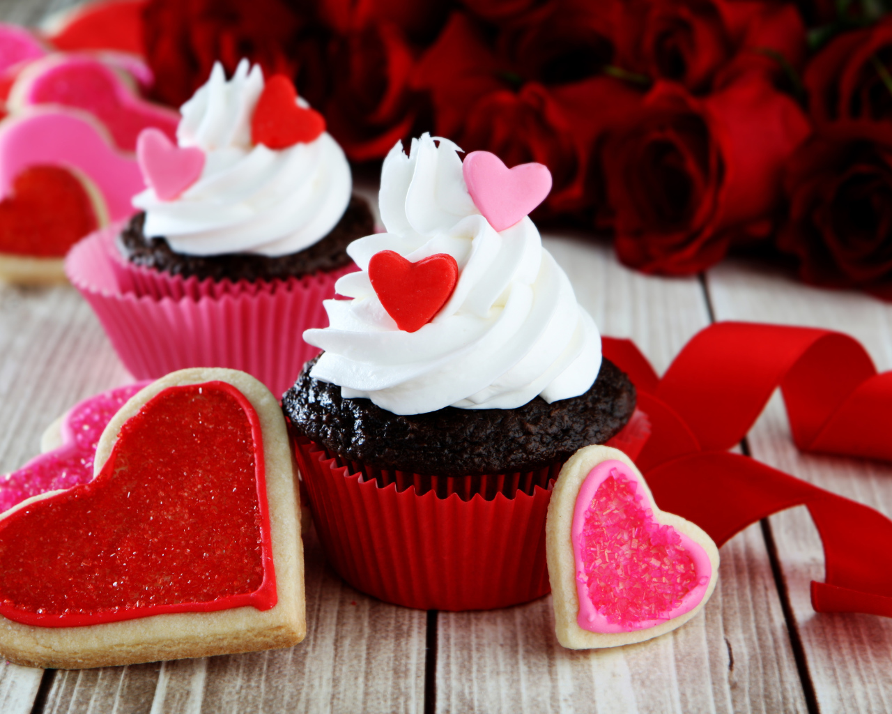 Капкейки с кремом и печенье в форме сердечек на столе