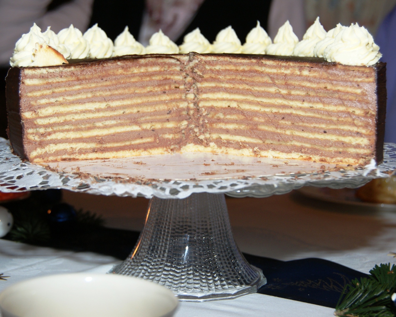 Разрезанный торт с кремом на стеклянном блюде