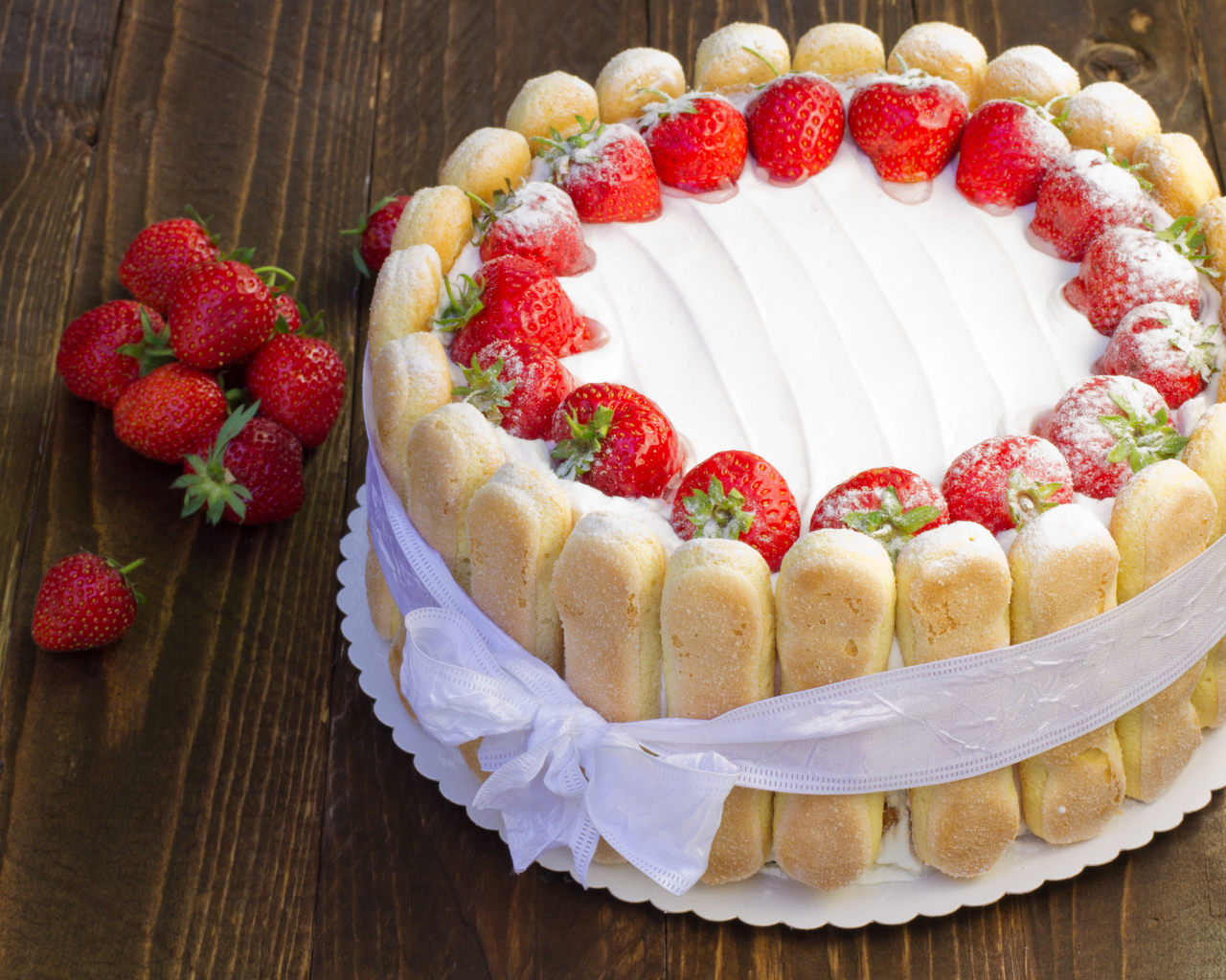 Вкусный торт с клубникой и печеньем перевязан бантом