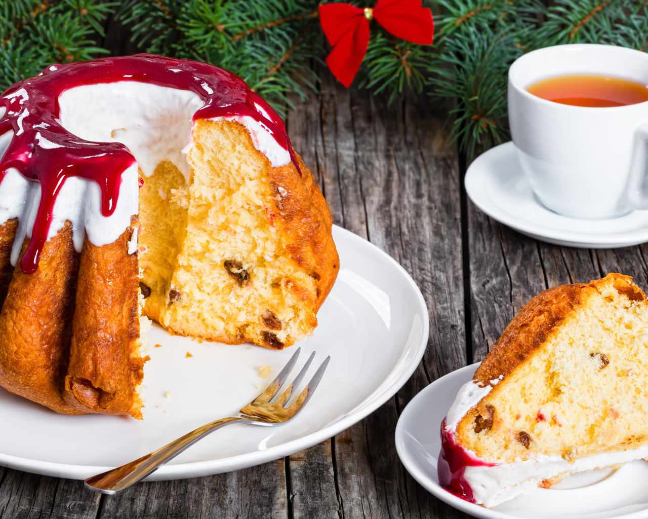 Праздничный кекс с глазурью на столе с чашкой чая