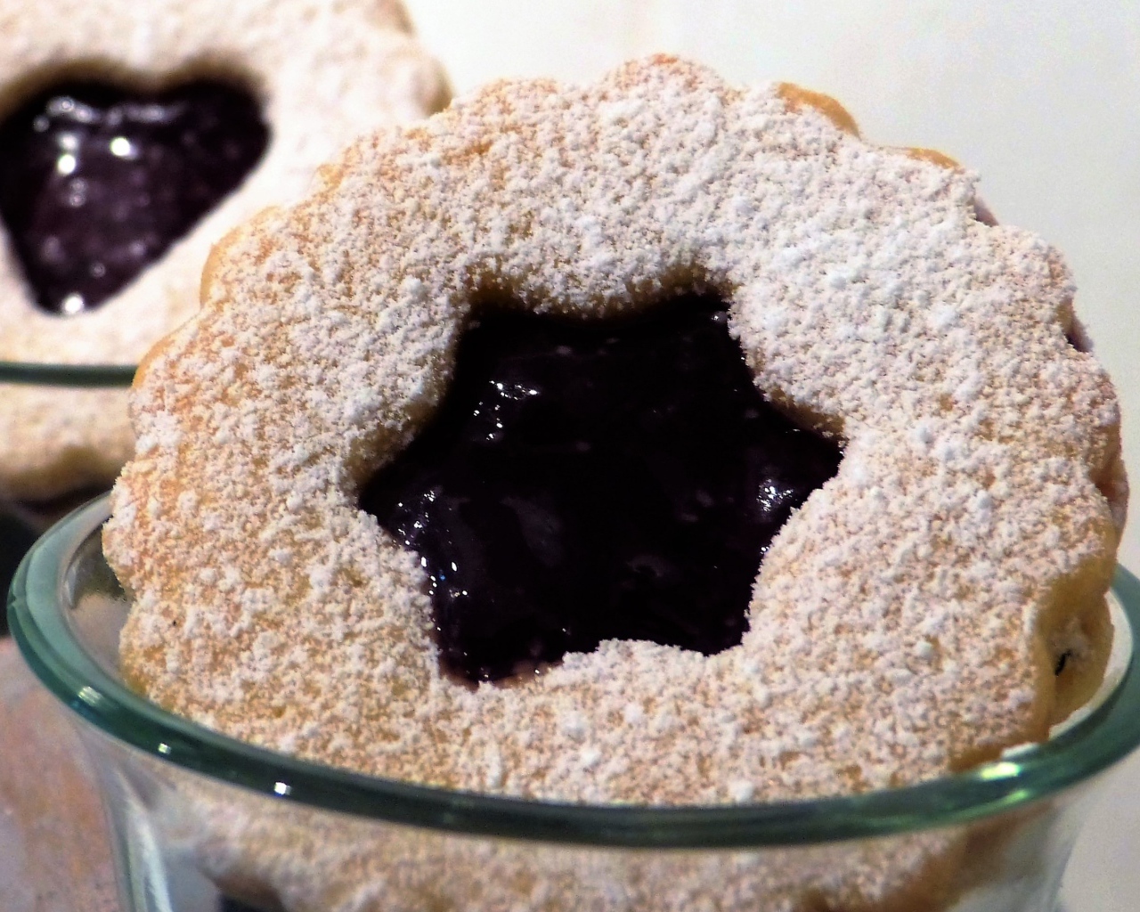 Фигурные печенья с джемом посыпанные сахарной пудрой 