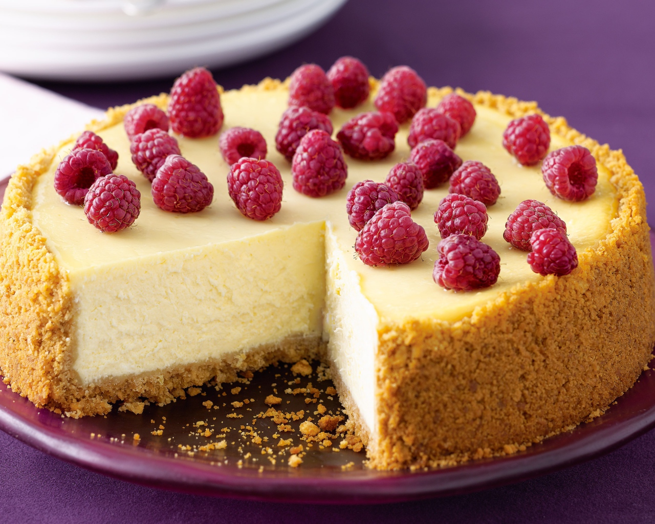 Свежий чизкейк с малиной на тарелке 