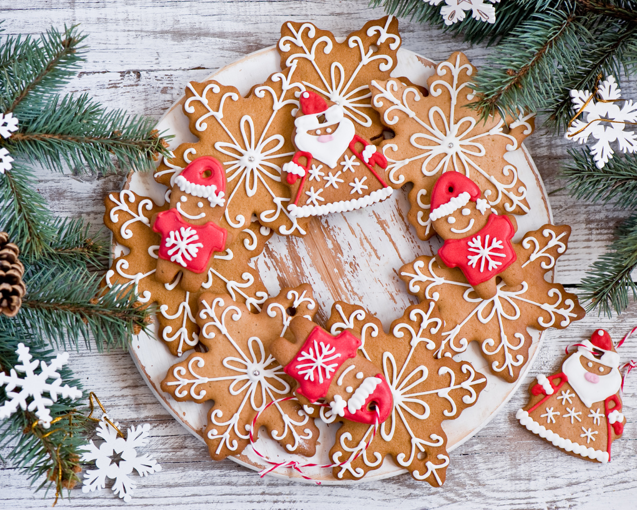 Имбирное новогоднее печенье с еловыми ветками на деревянном столе
