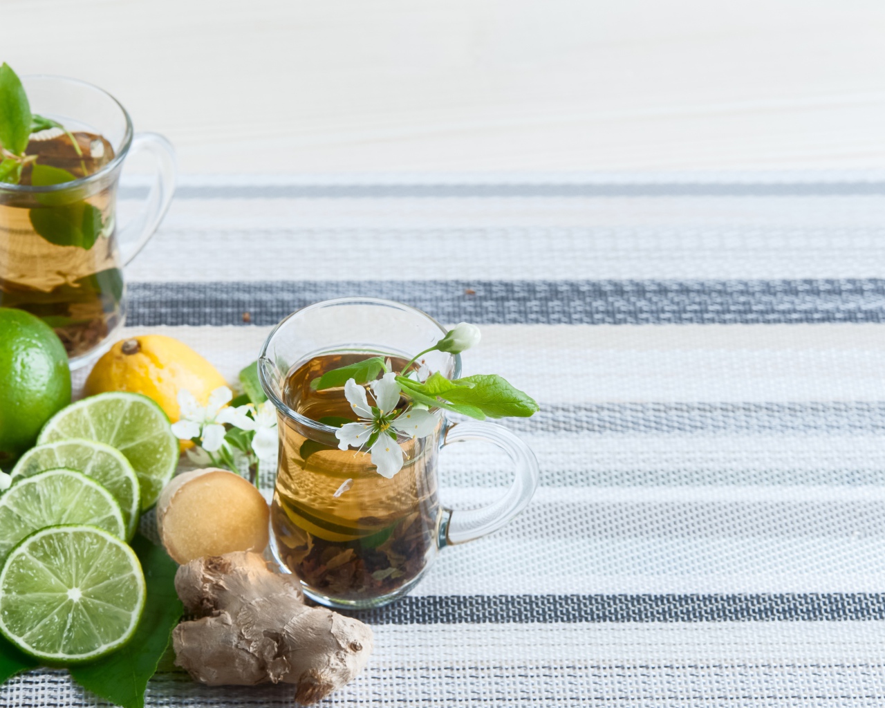 Стеклянные чашки с чаем на столе с имбирем и лаймом