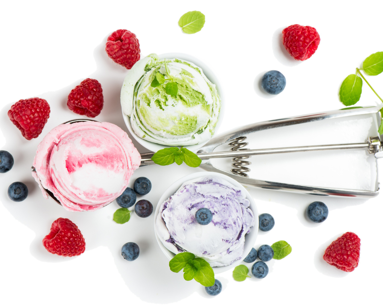 Шарики мороженого на столе с ягодами черники и малины 