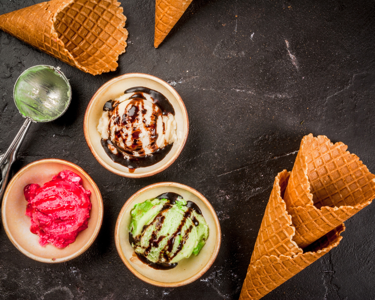 Шарики мороженого с вафельными рожками на столе 