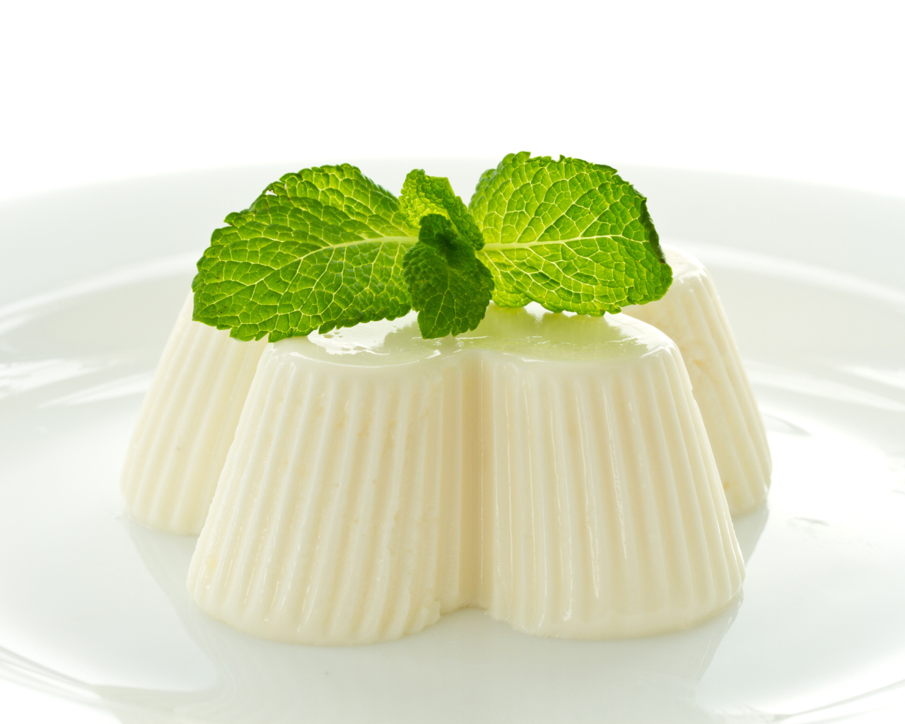 Молочное желе с мятой на белой тарелке 