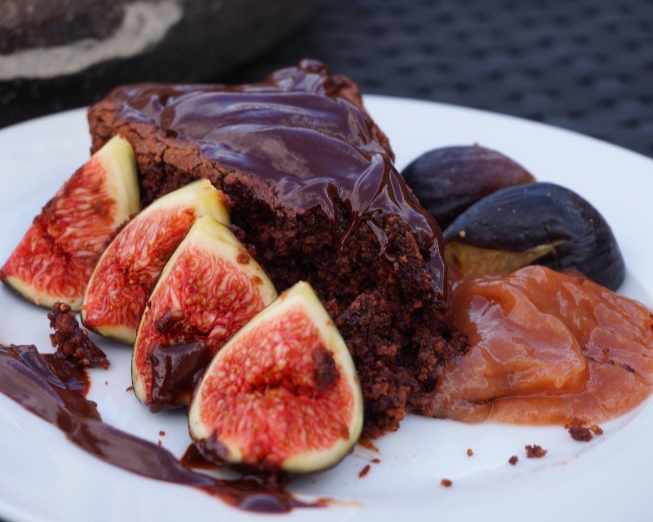 Кусок пирога с шоколадом на тарелке с кусочками инжира