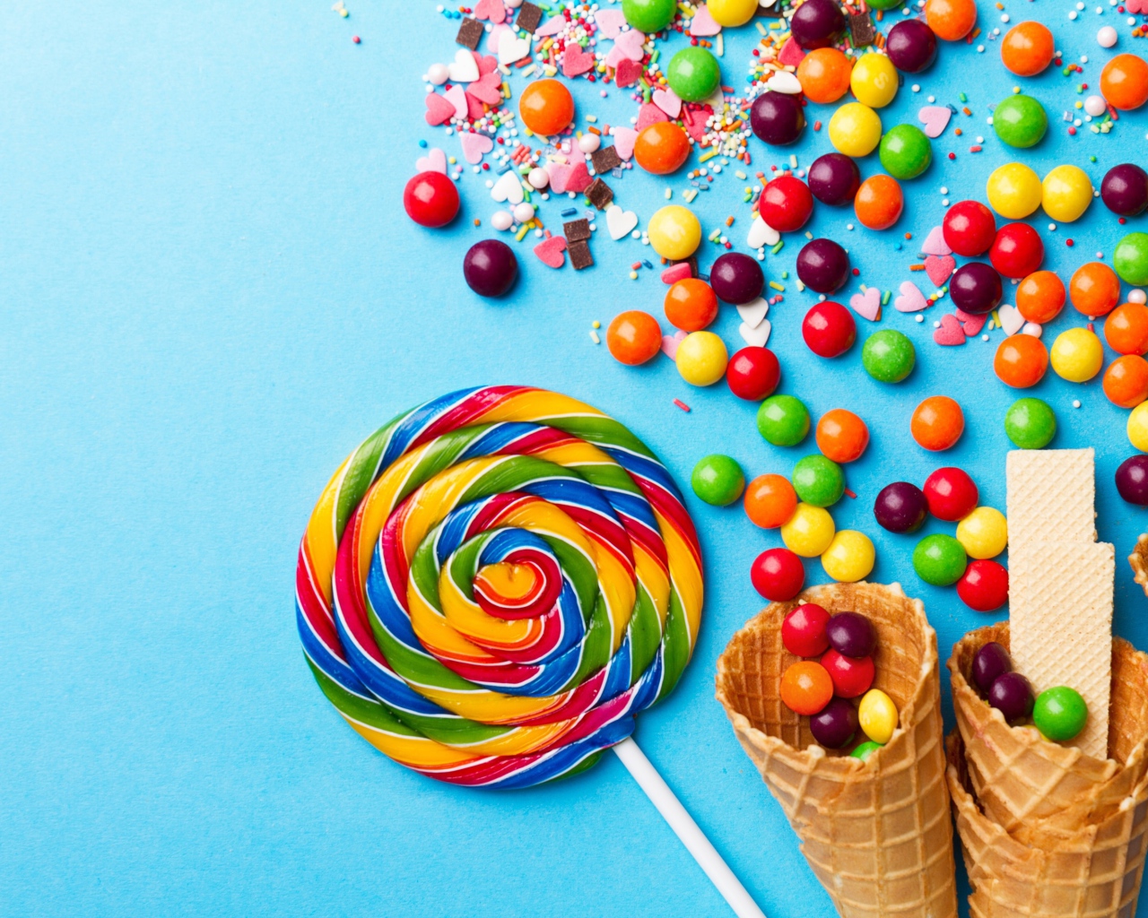 Сладкие конфеты и вафельные рожки на голубом фоне