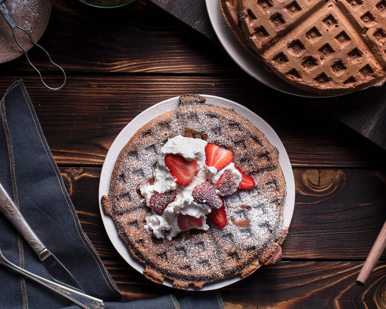 Сладкие вафли со сливками и ягодами клубники 