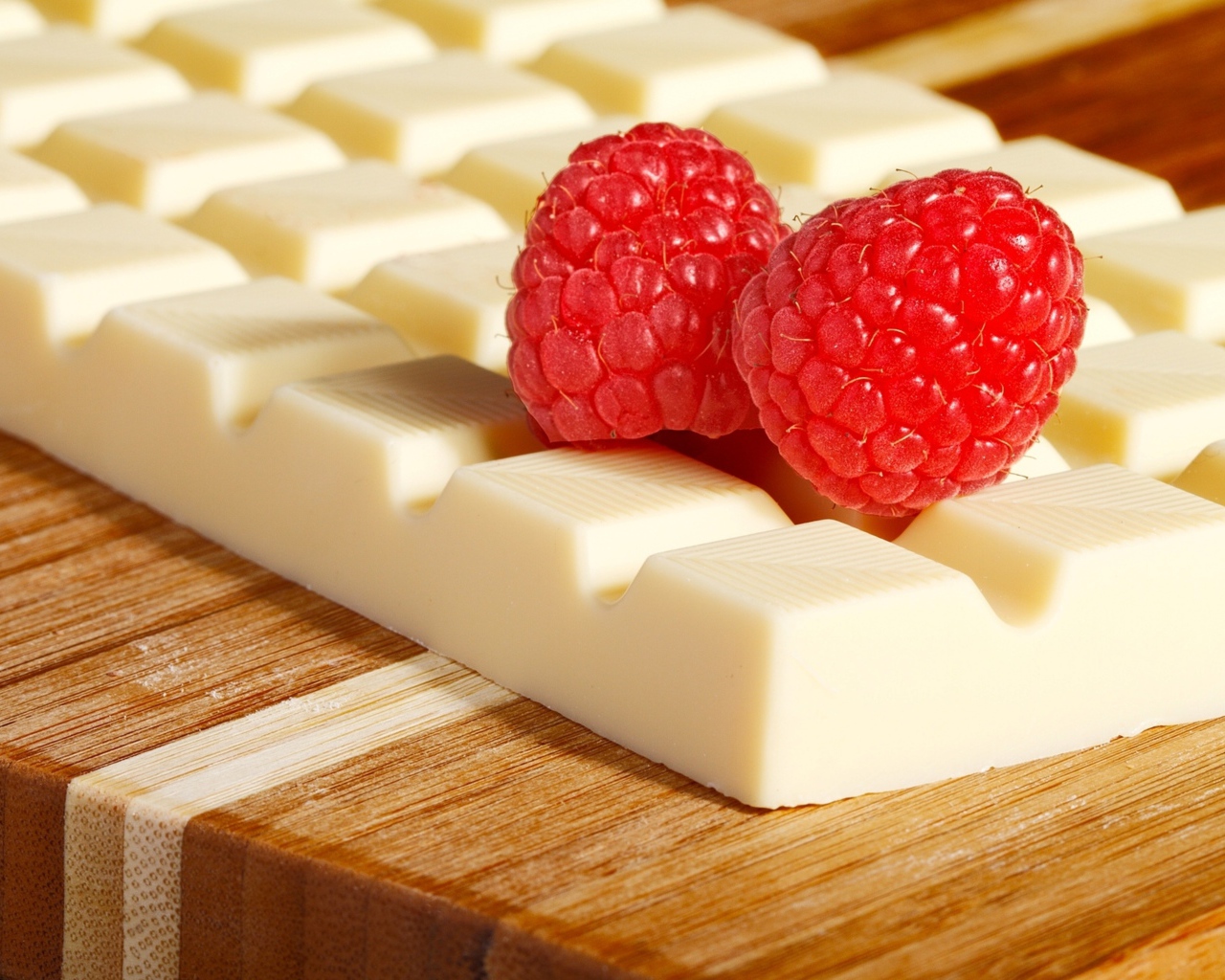 Сладкий белый шоколад с ягодами малины на столе