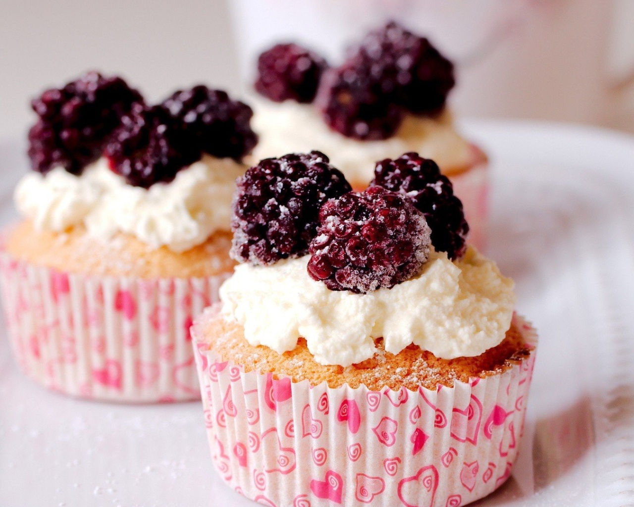 Три кекса с кремом и замороженной малиной