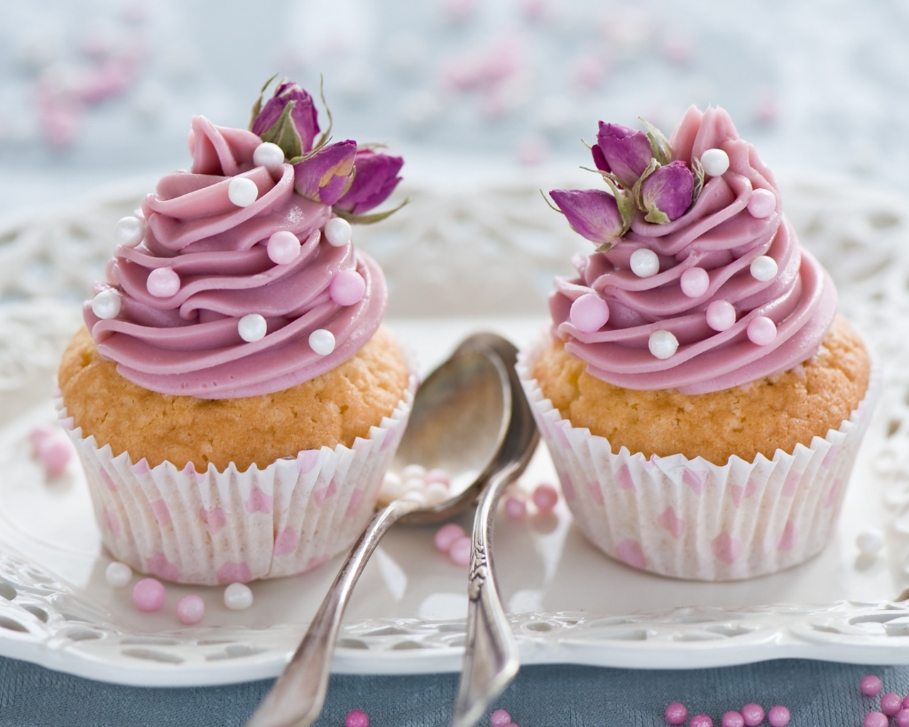 Два вкусных капкейка с кремом на тарелке