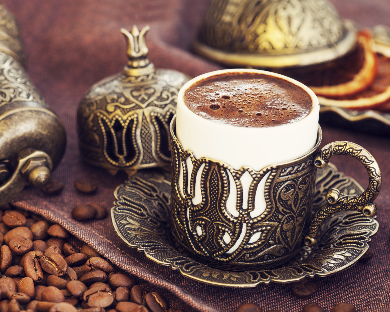 Красивая дизайнерская чашка кофе на столе с зернами