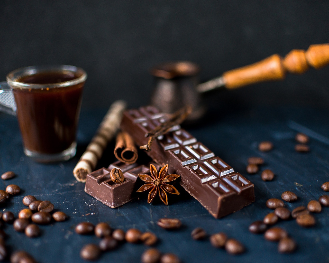 Чашка кофе на столе с шоколадом и зернами кофе