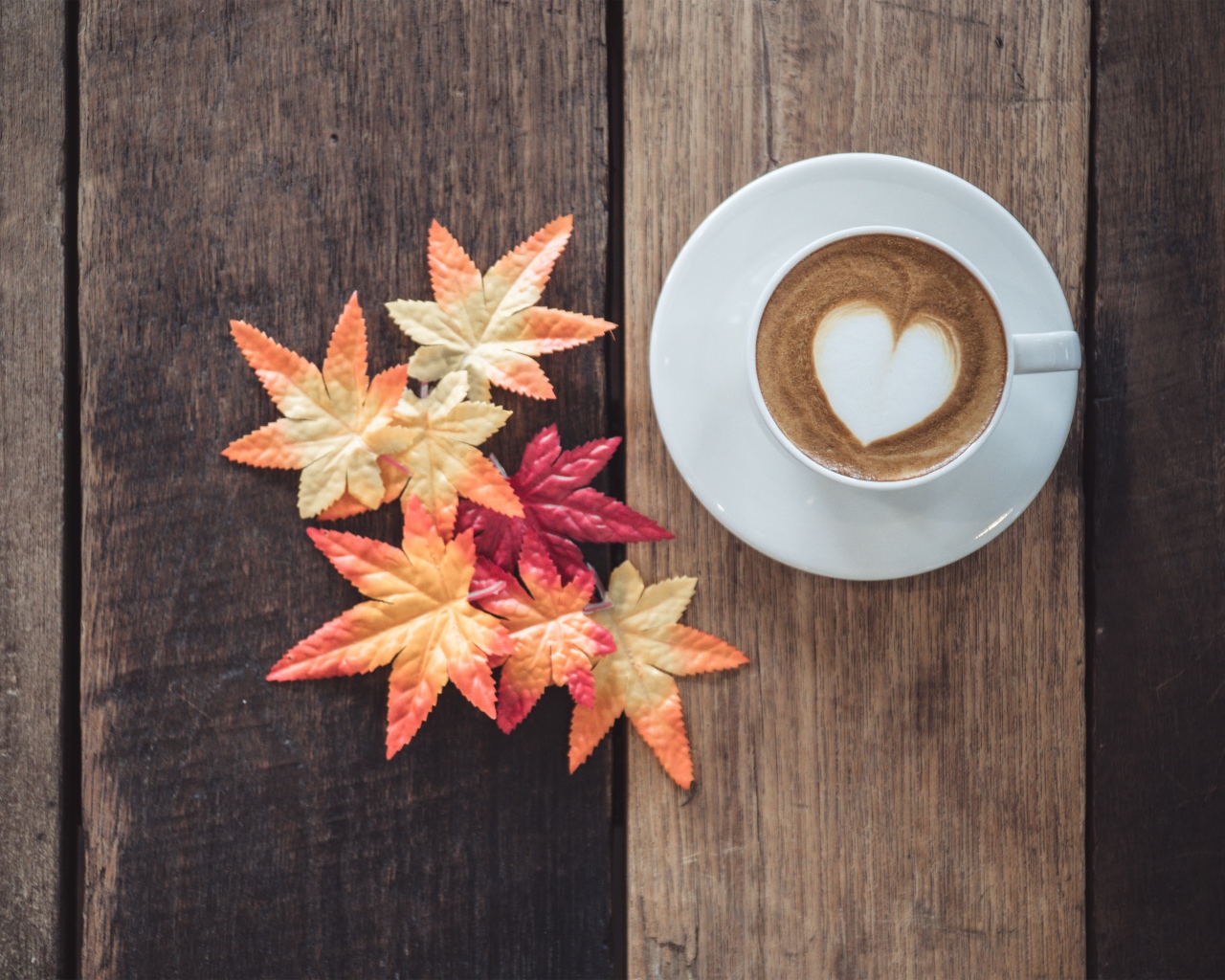 Чашка кофе на деревянном столе с желтыми листьями