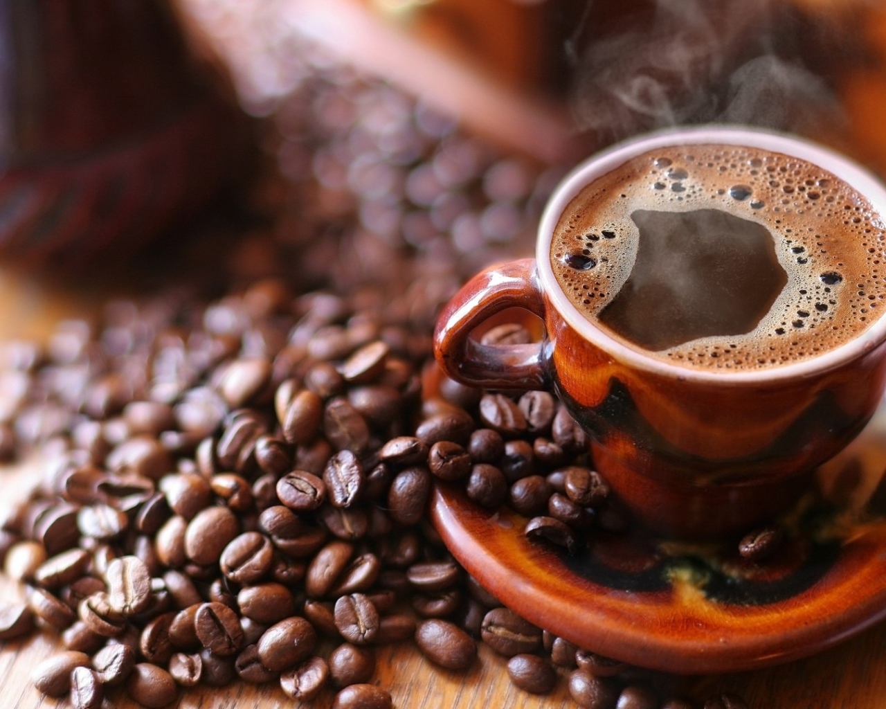 Чашка горячего кофе на столе с кофе 