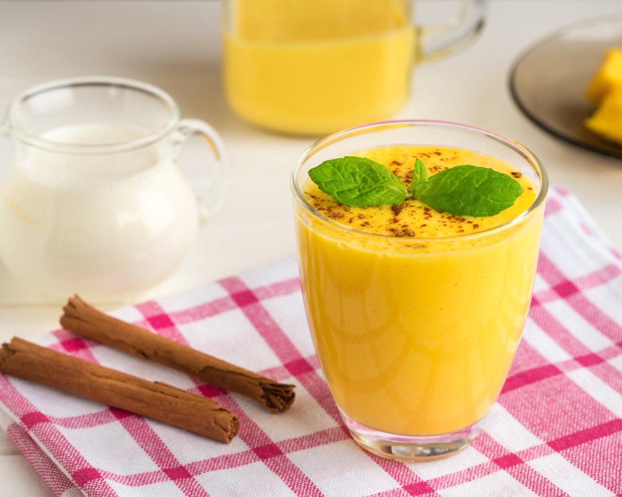 Стакан сока на столе с молоком и корицей