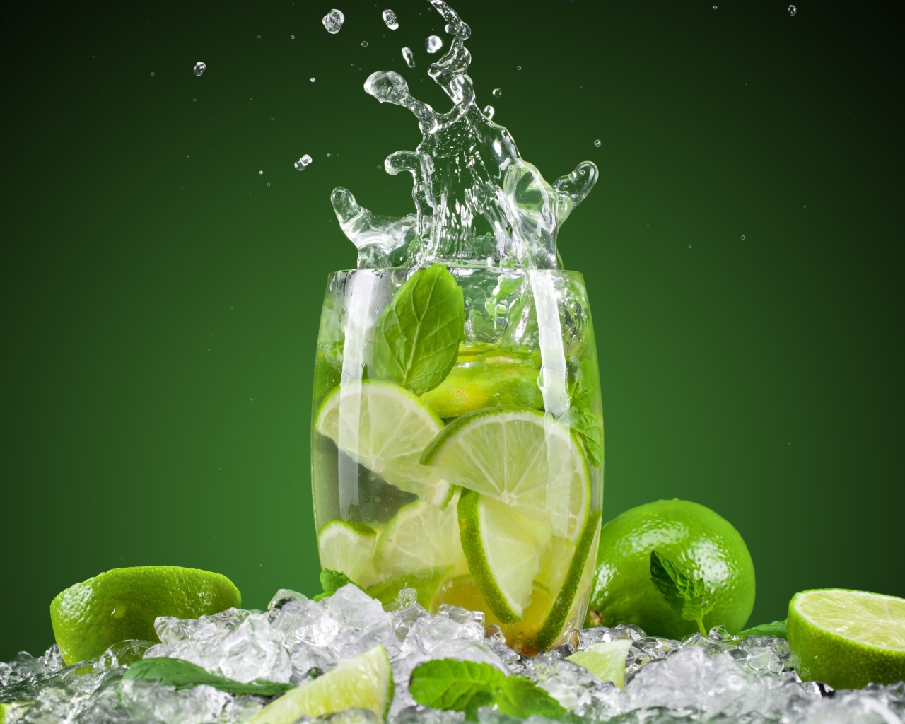 Стакан с лимонадом стоит на кусочках льда с лаймом