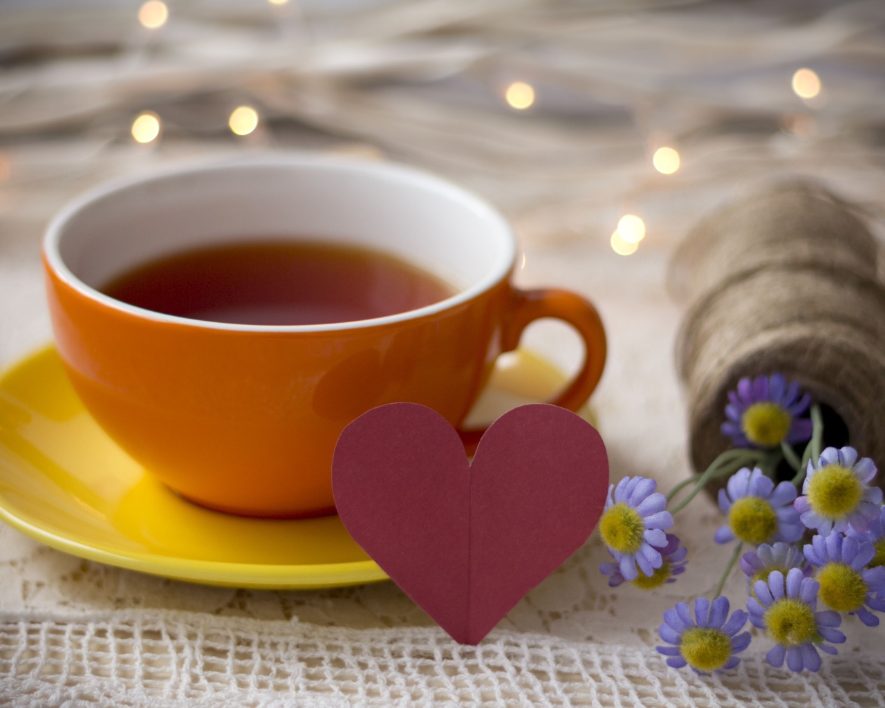Большая чашка чая на столе с розовым бумажным сердцем и цветами